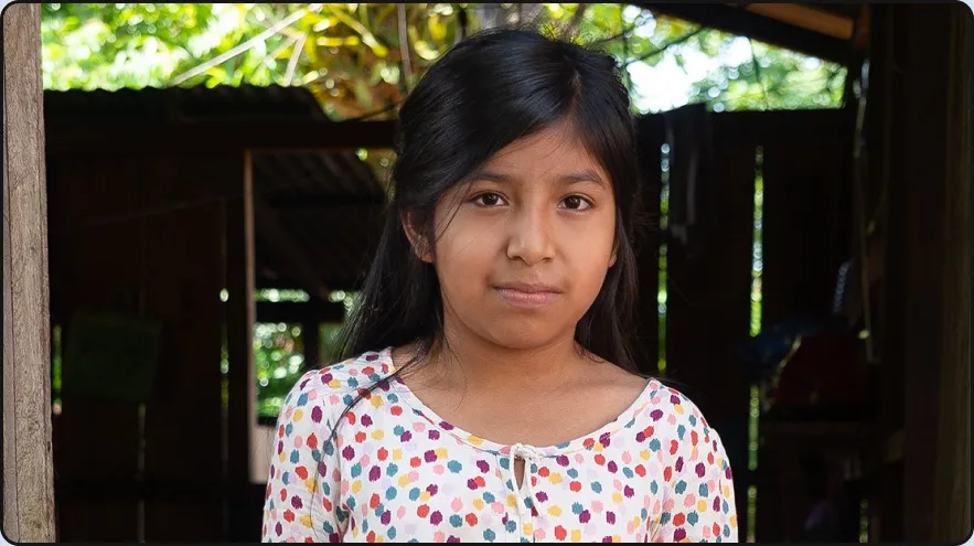 A girl standing at the doorway of her home