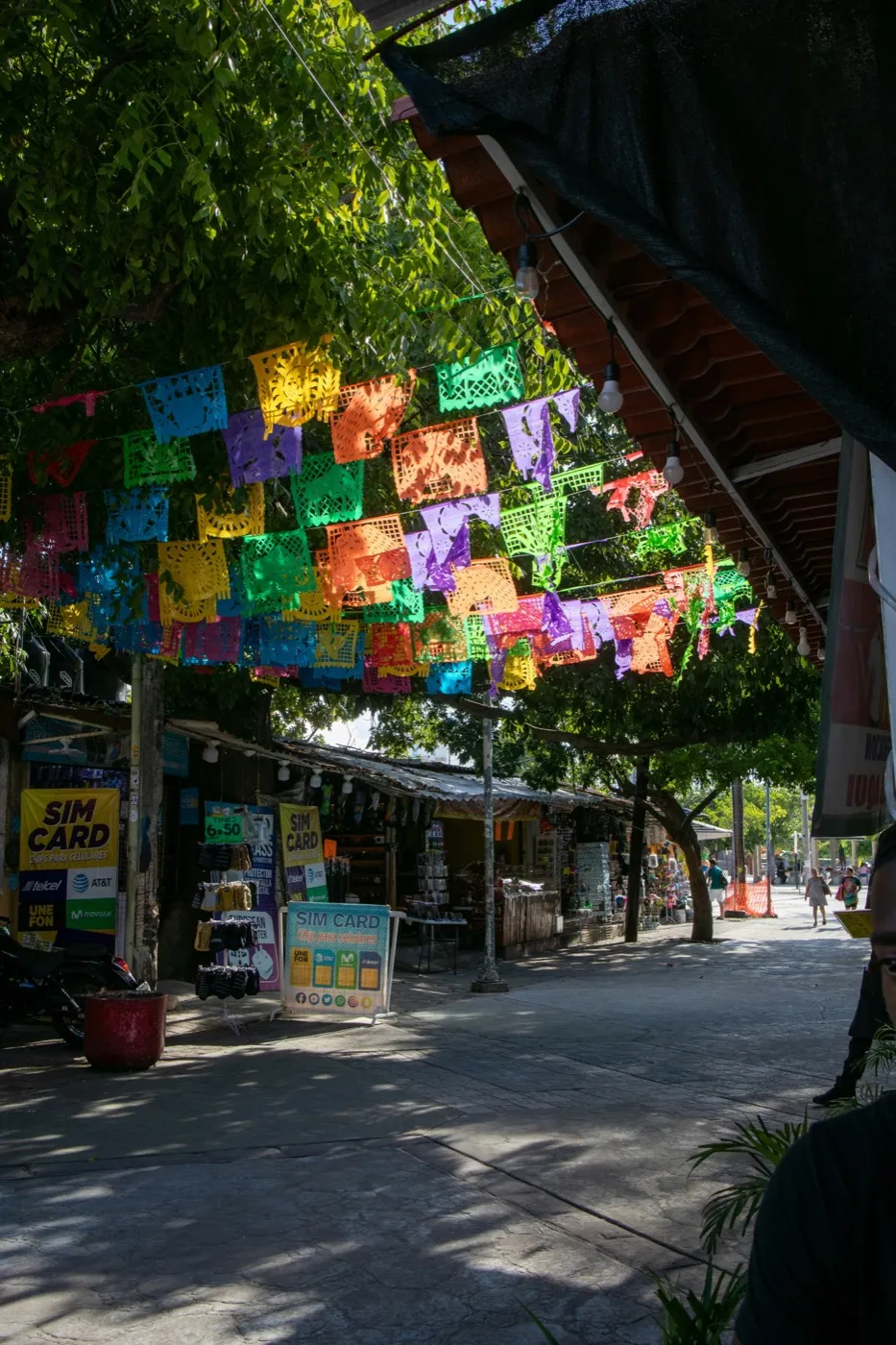 Papel picado banners strung above a lively market street