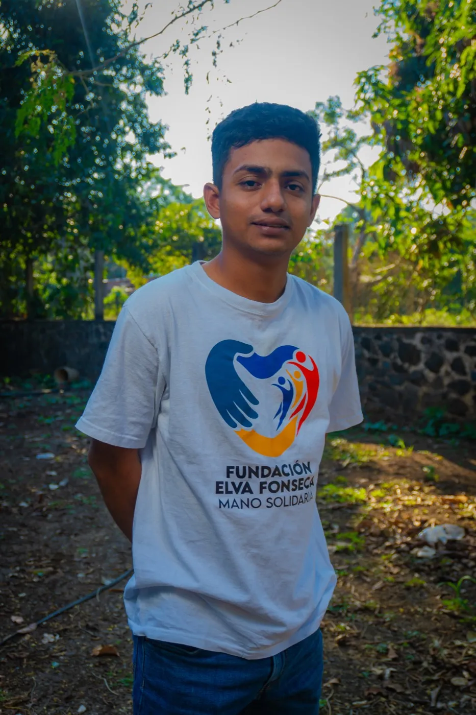 Carlos Toto standing outdoors, wearing a Fundación Elva Fonseca t-shirt